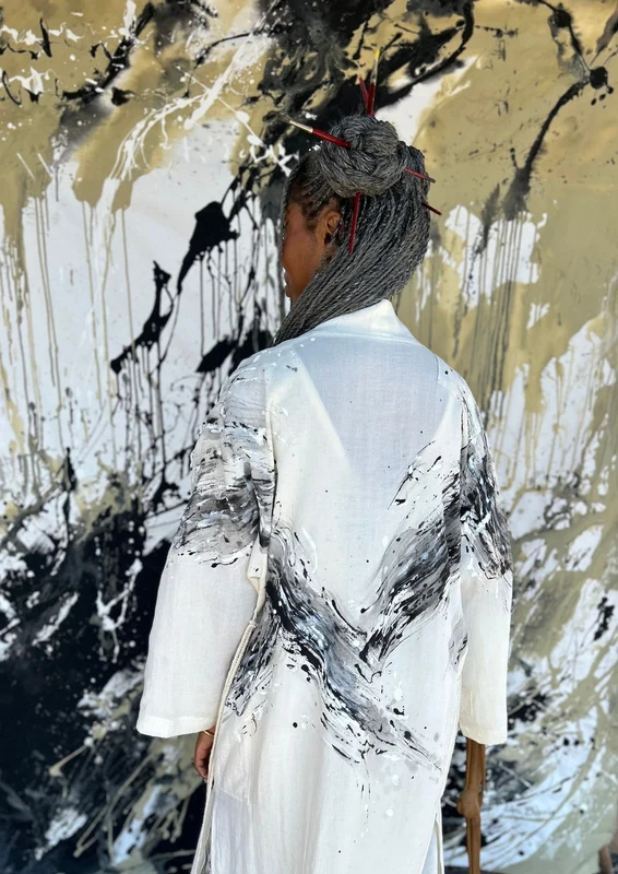 Hand-painted white coat with black abstract brushwork, seen from the back